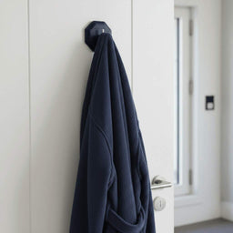 ScrubMe HookMe Breathtaking Blue adhesive hook holding a navy bathrobe on a white bathroom door.
