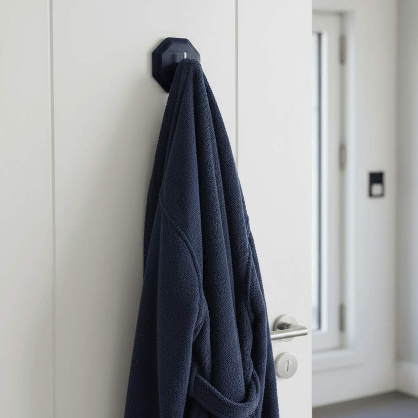 ScrubMe HookMe Breathtaking Blue adhesive hook holding a navy bathrobe on a white bathroom door.