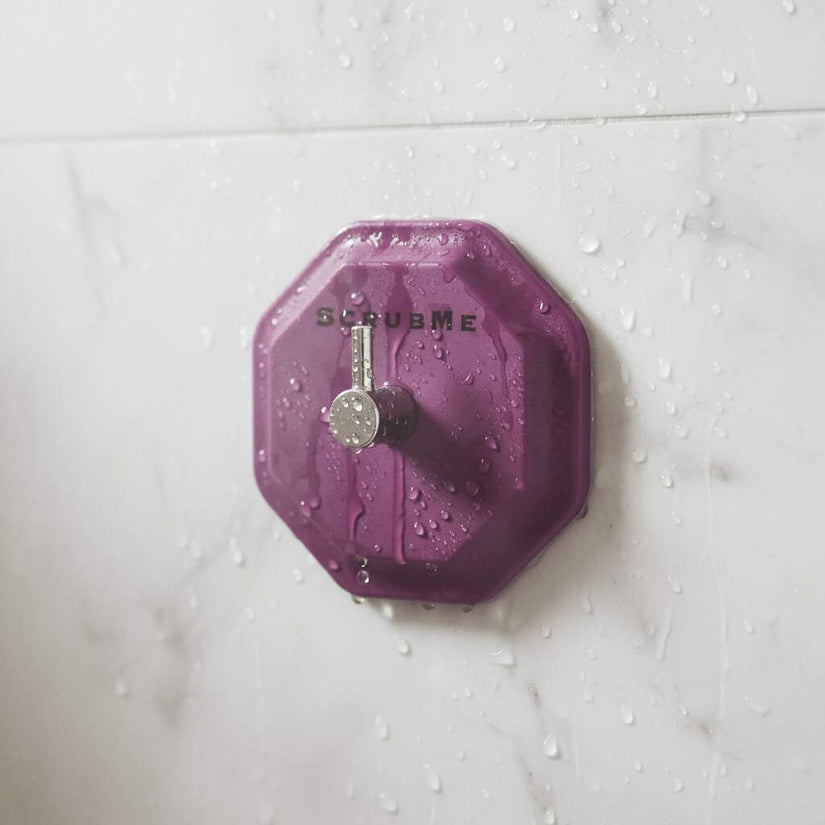 ScrubMe HookMe Passionate Purple hook mounted on wet marble shower tiles with water drops.