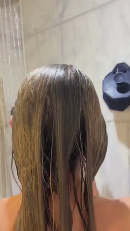 Lifestyle video of a woman massaging shampoo through her hair with the ScrubMeScalp Passionate Purple silicone scalp massager for healthier scalp and hair growth.