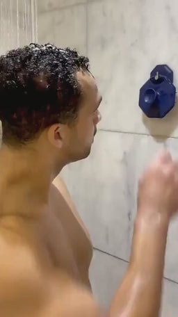 Lifestyle video of a man using the ScrubMeScalp Breathtaking Blue silicone scalp massager in the shower to deep clean his scalp and help reduce dandruff.