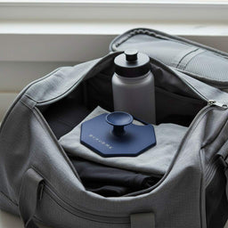 ScrubMeBody Breathtaking Blue body scrubber packed in a grey gym bag with workout clothes and a water bottle, ready for the gym or travel.