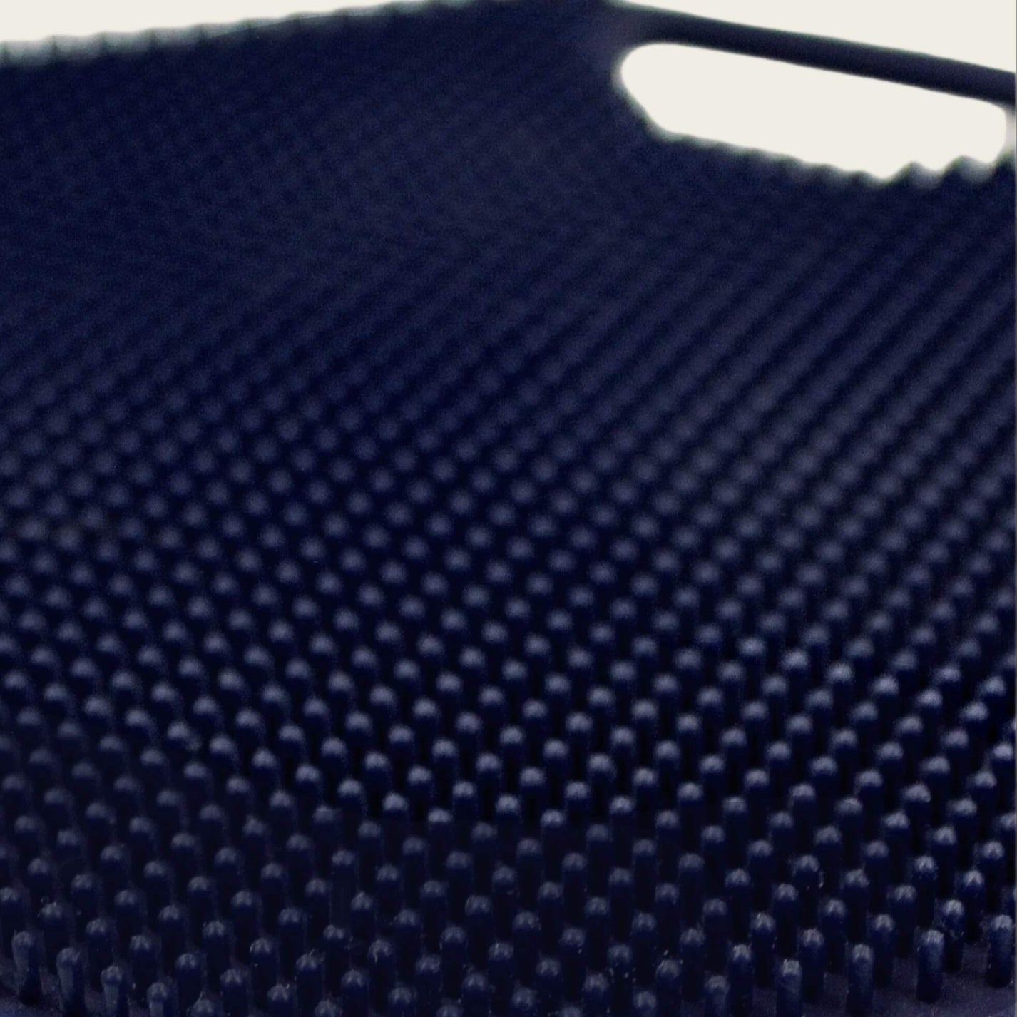 Close-up of the ScrubMeBody Breathtaking Blue body scrubber showing hundreds of tiny silicone exfoliating bristles in a dense grid pattern.