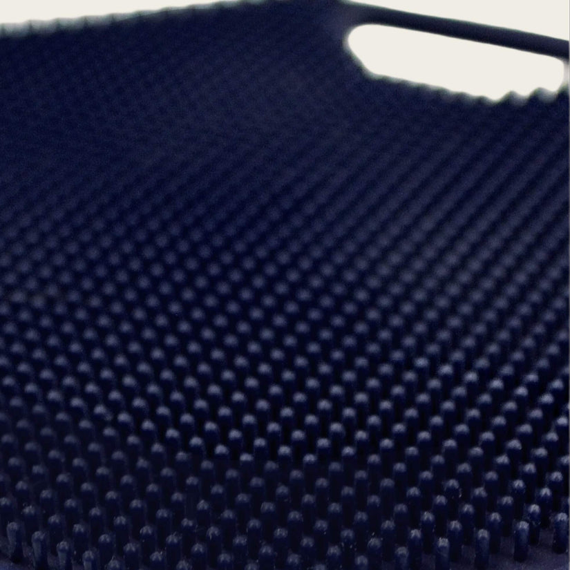 Close-up of the ScrubMeBody Breathtaking Blue body scrubber showing hundreds of tiny silicone exfoliating bristles in a dense grid pattern.