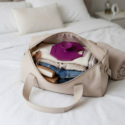 ScrubMeBody Passionate Purple body scrubber packed neatly inside a beige weekend bag with folded jeans and accessories.