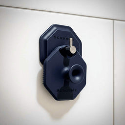 ScrubMeFace Breathtaking Blue face scrubber hanging neatly on a HookMe holder against white bathroom tiles.