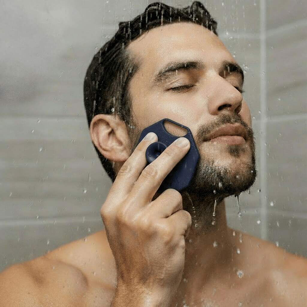 Man cleansing his face under the shower using the ScrubMeFace Breathtaking Blue silicone face scrubber.