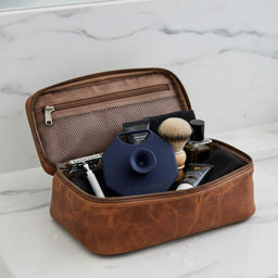 Breathtaking Blue ScrubMeFace face scrubber packed in brown leather wash bag on marble surface.