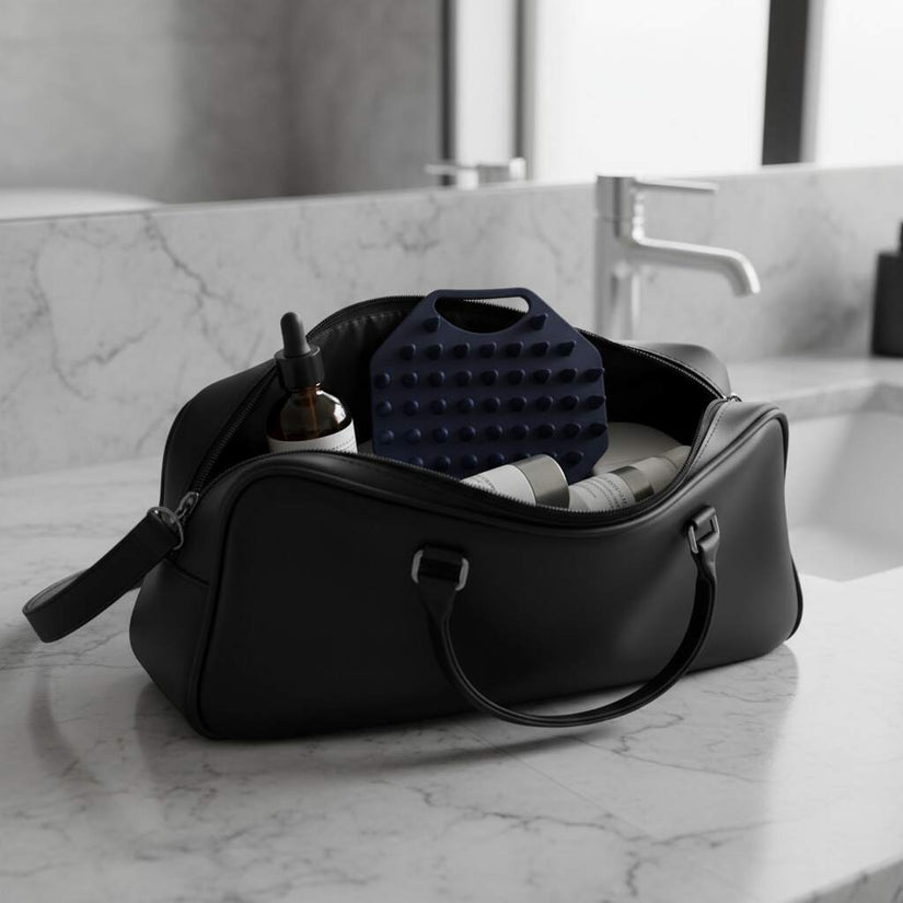 ScrubMeScalp Breathtaking Blue scalp scrubber in a black travel was bag with hair and body products on a
bathroom counter