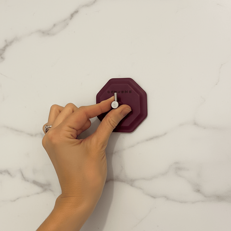 Woman installing HookMe on marble tile